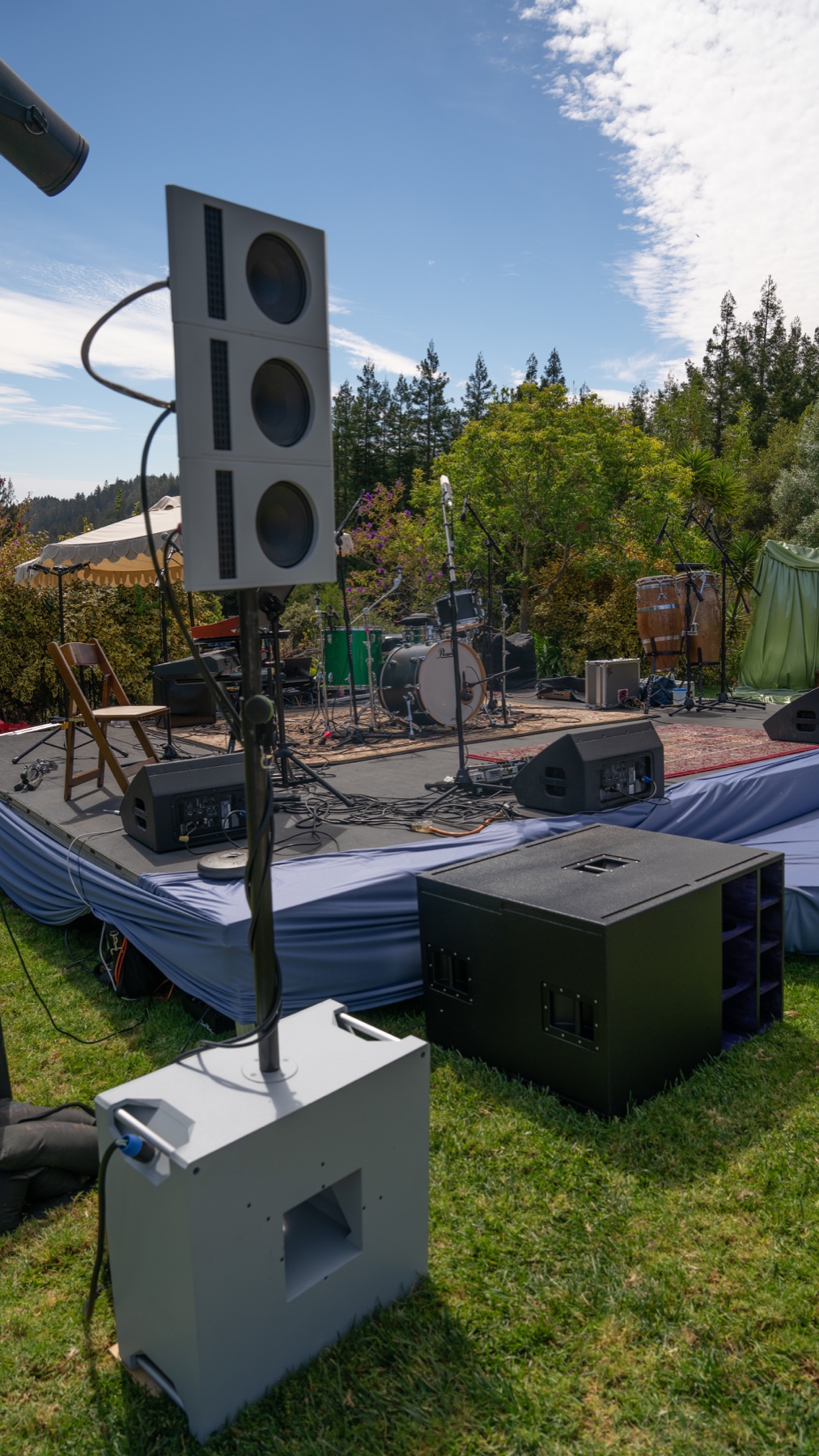 A close view of a compact high-fidelity loudspeaker system beside a prepared performance stage